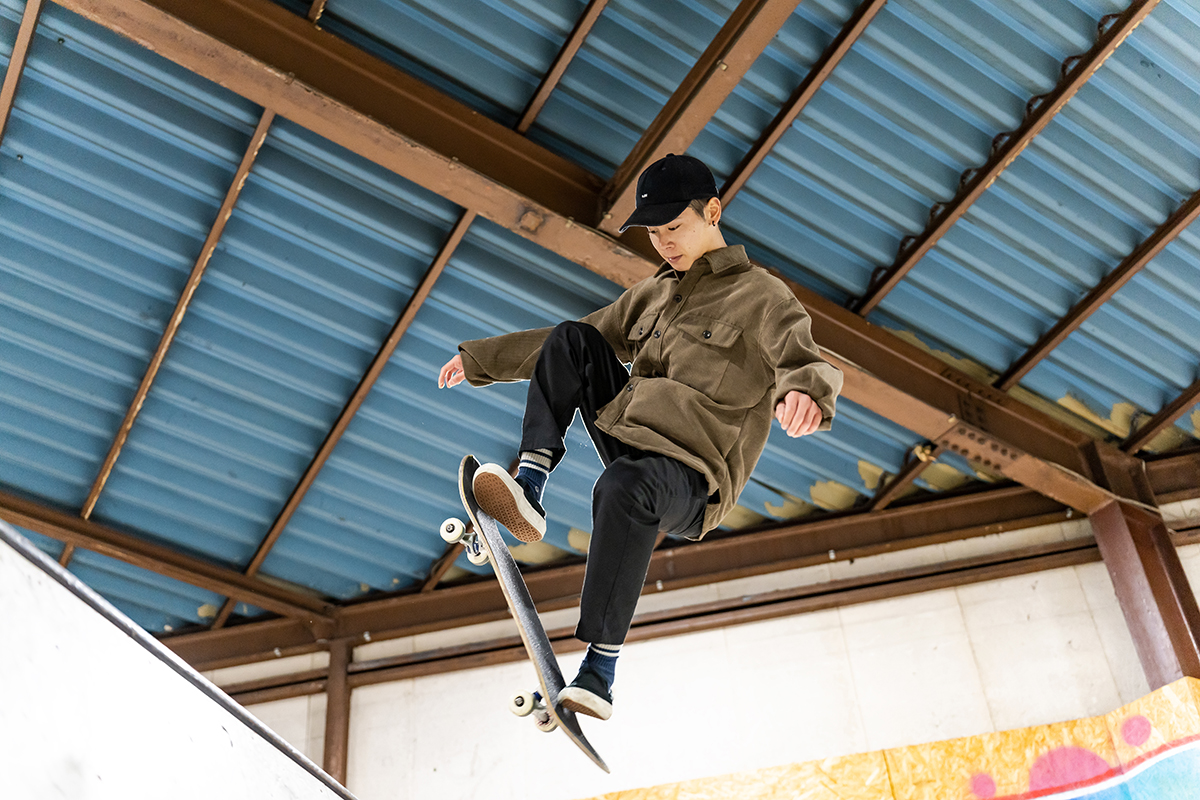 Un joven patinador realiza un truco en el aire bajo una estructura metálica, capturado mientras fotografiaba deportes extremos con el 35-150 mm F2-2,8 de TAMRON.