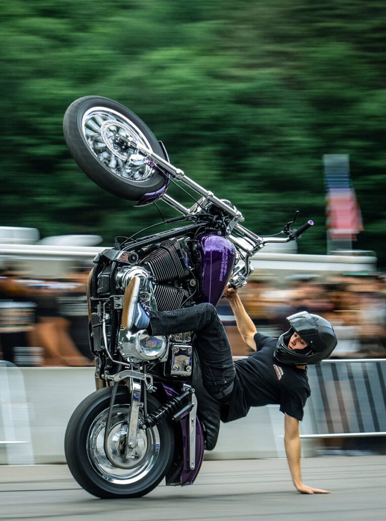 Un gars qui fait un wheelie sur un vélo violet.