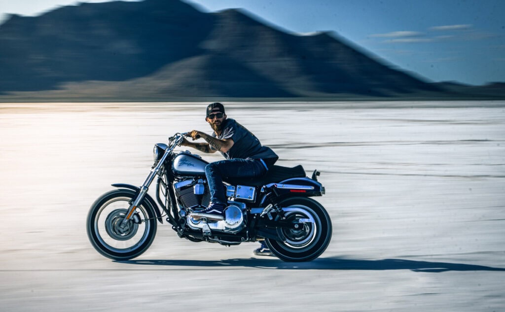 Motocycliste conduisant avec des montagnes en arrière-plan.