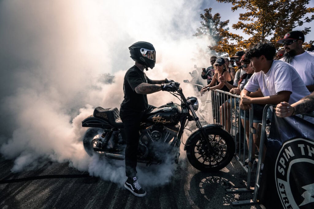 Motocycliste parlant à la foule avec de la fumée autour d'eux.