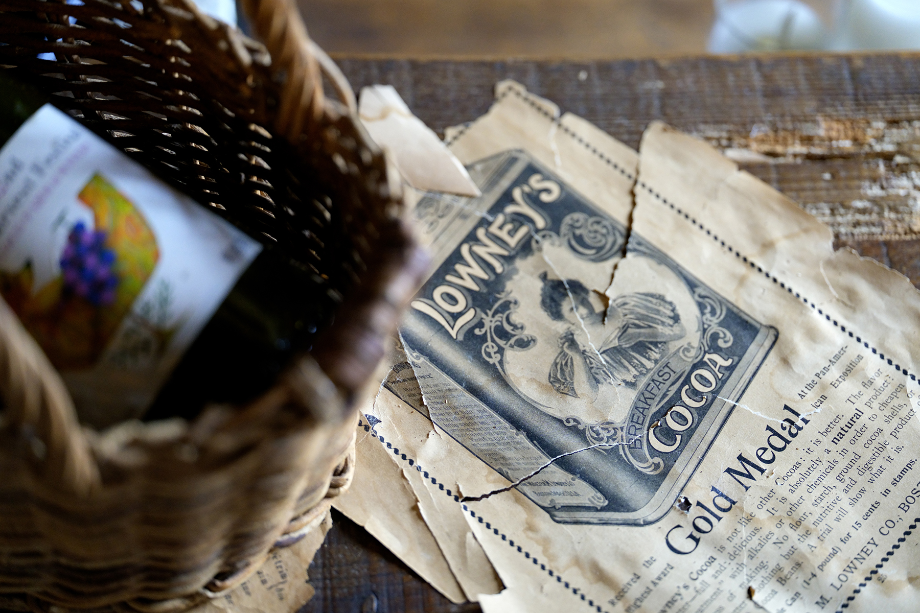 Close-up photograph of vintage Lowney's cocoa advertisement and woven basket.