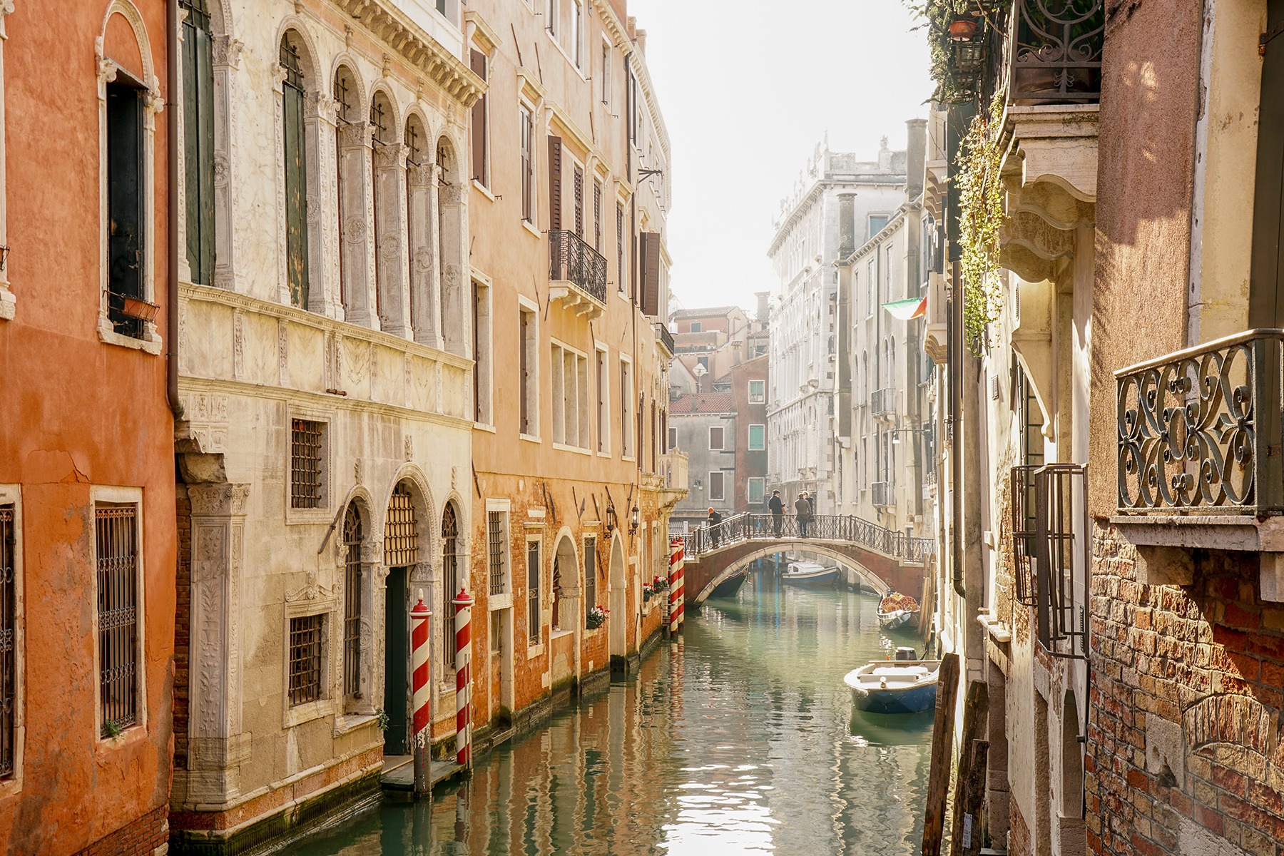 A picturesque Venetian canal lined with historic buildings, featuring a quaint bridge and calm waters photographed with a Tamron E-Mount APS-C Lens.