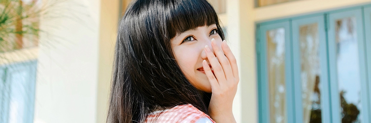 Joven sonriente con luz natural, capturada con un objetivo Tamron Fujifilm con montura X, que ofrece un enfoque nítido en los ojos y un bokeh suave para obtener retratos de calidad profesional.