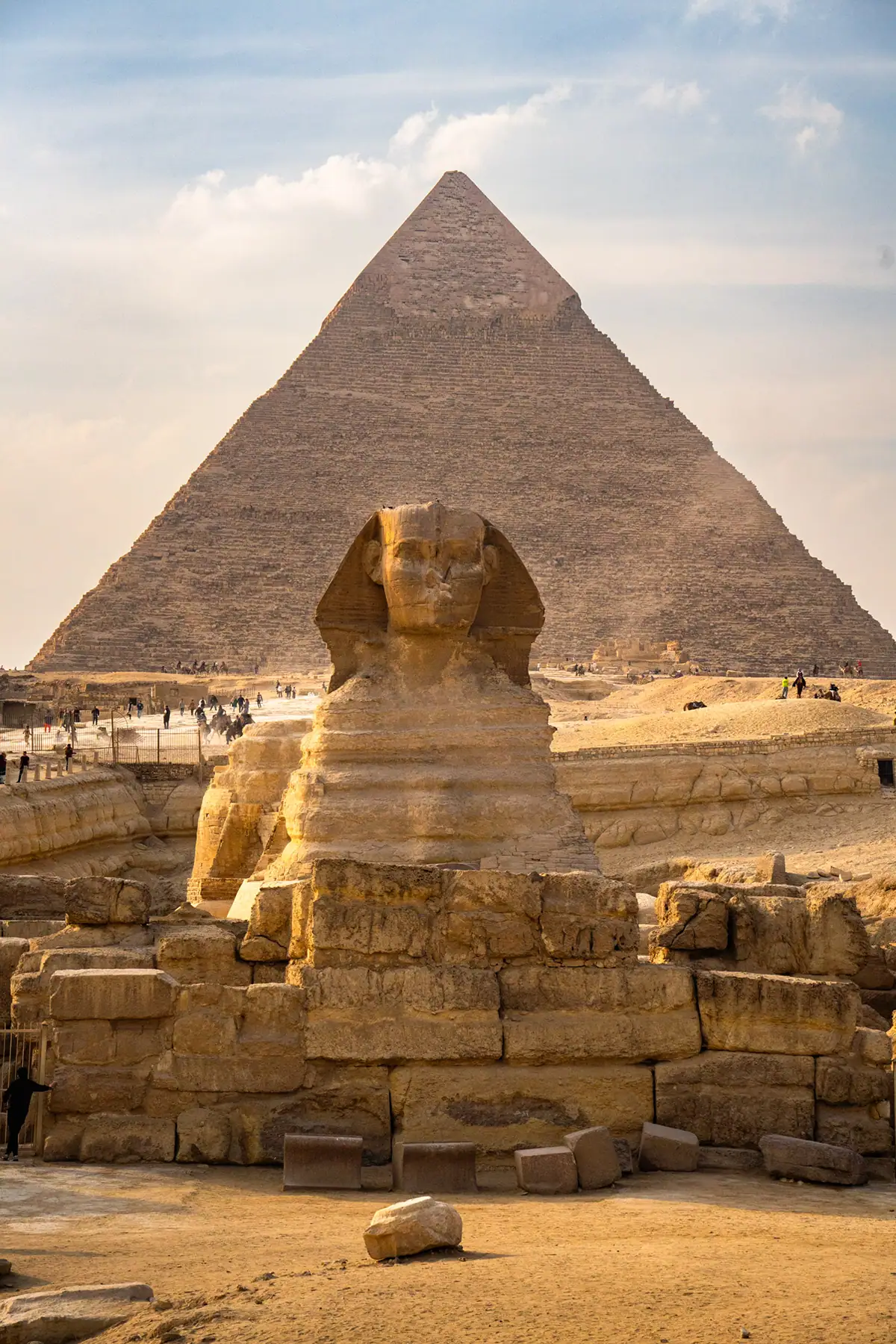 The Great Sphinx of Giza with the Pyramid of Khafre in the background under a golden sky, an essential stop when you photograph historical landmarks in Egypt.