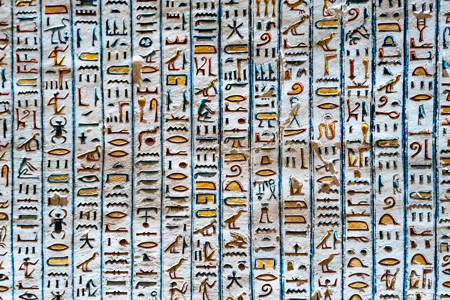 Vividly colored ancient Egyptian hieroglyphs carved into a temple wall in Luxor, a fascinating detail to capture as you photograph historical landmarks in Egypt.
