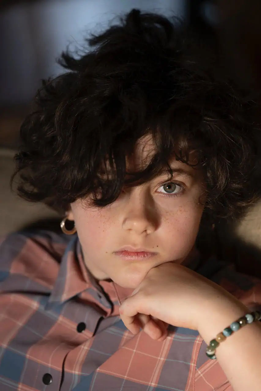 Close-up portrait of a child with soft natural window light highlighting the face&mdash;an intimate example of photographing portraits in early morning light.