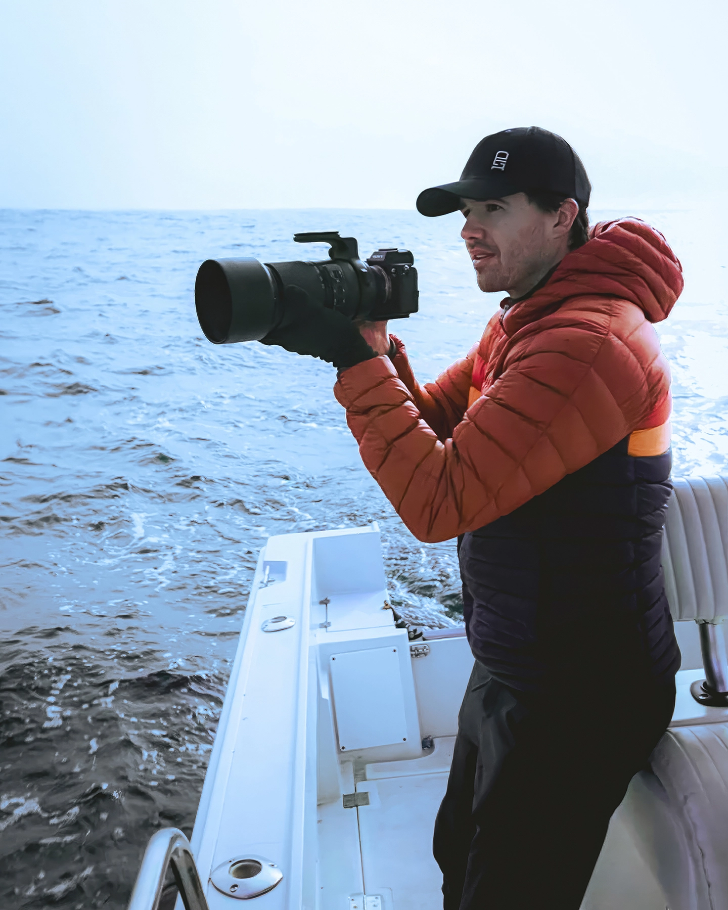 Seth Macey fotografiando la costa de California con un objetivo Tamron 150-500 mm, listo para capturar la fauna marina desde una embarcación.
