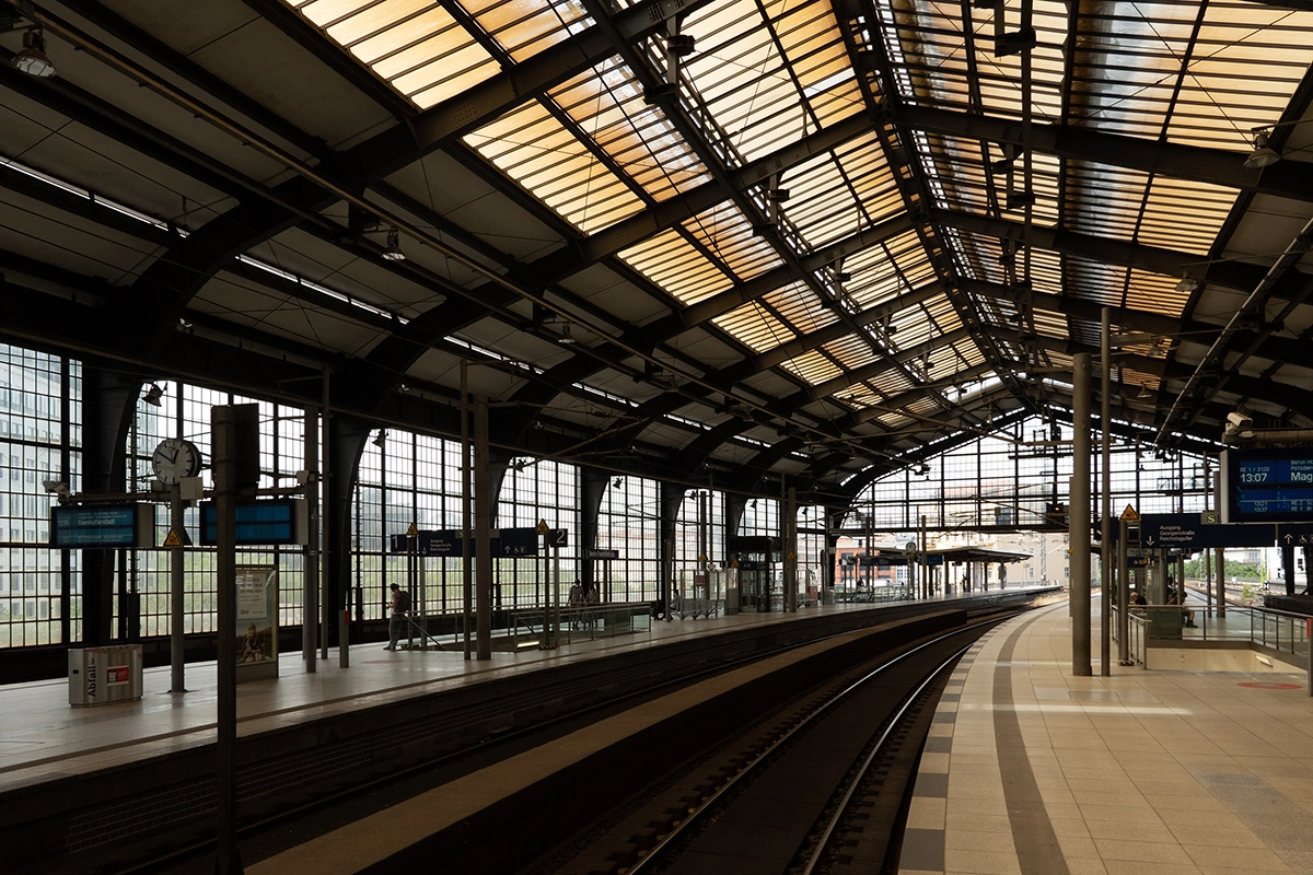 El andén vacío de una estación de tren con una espectacular arquitectura de cristal y acero, captado con luz natural: una escena ideal que muestra la claridad y la perspectiva que se pueden conseguir con el mejor objetivo para fotografía de viajes.