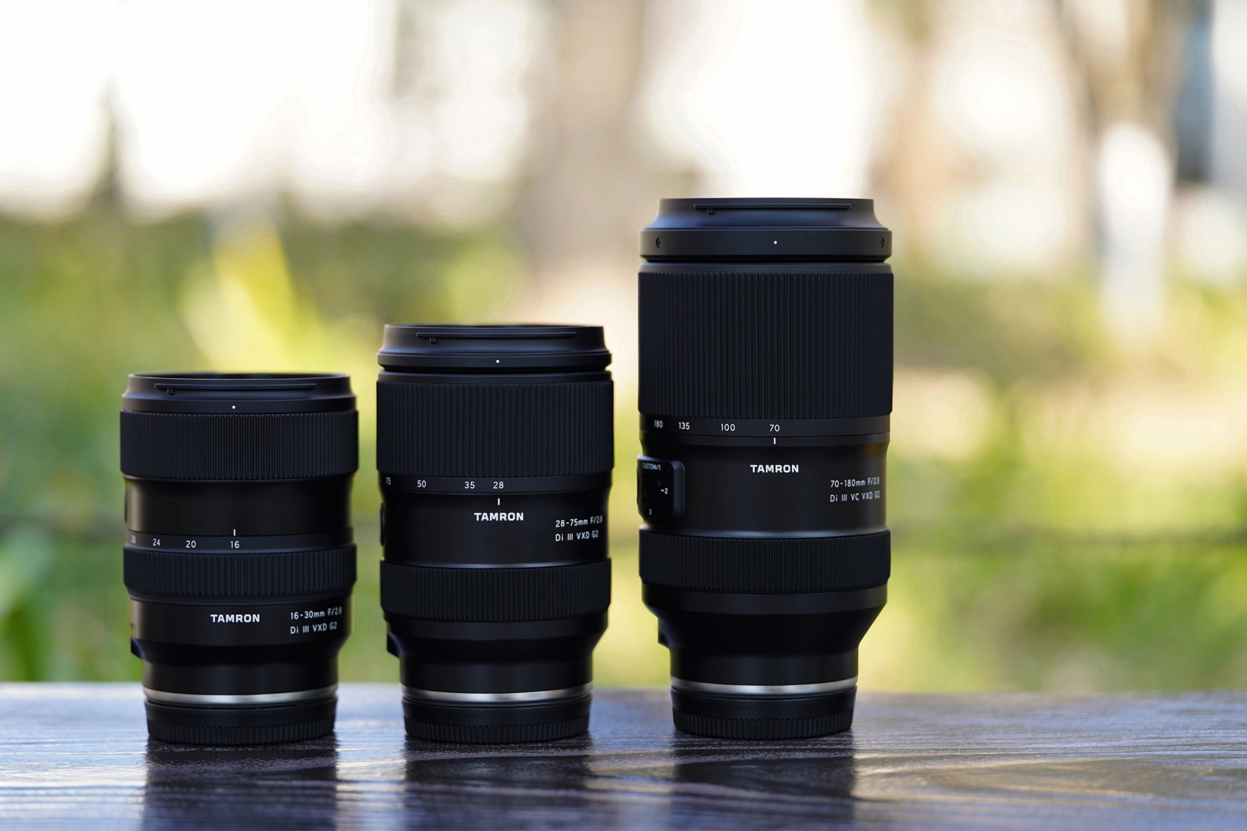 The Tamron G2 trinity lens lineup displayed side by side: 16-30mm F2.8 G2, 28-75mm F2.8 G2, and 70-180mm F2.8 G2—showcasing a lightweight, fast-aperture trio for mirrorless cameras.