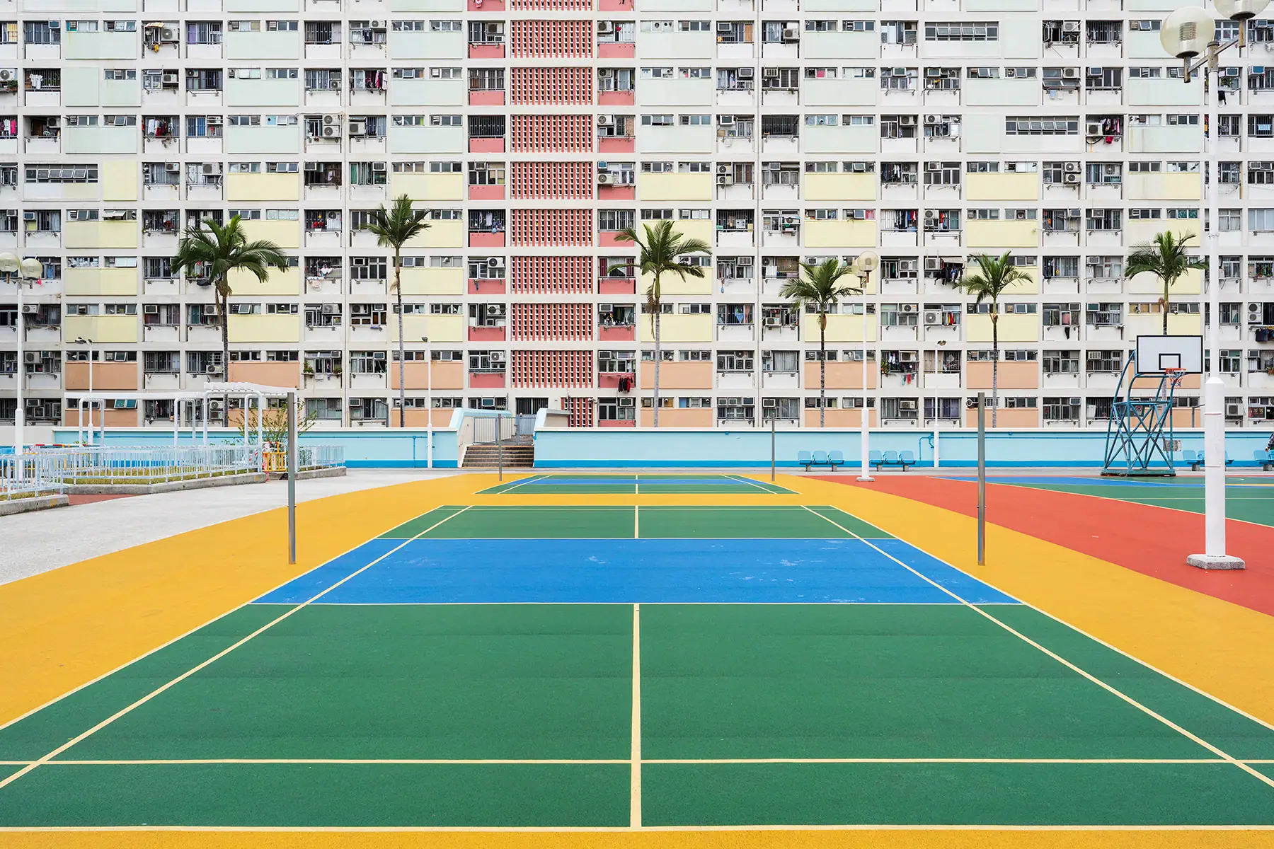 Vue symétrique d'une cour extérieure colorée et d'un arrière-plan d'appartements de grande hauteur, capturée lors de l'examen du Tamron 16-30 mm F2.8 G2 - montrant des lignes droites, des couleurs vives et une netteté d'un coin à l'autre.