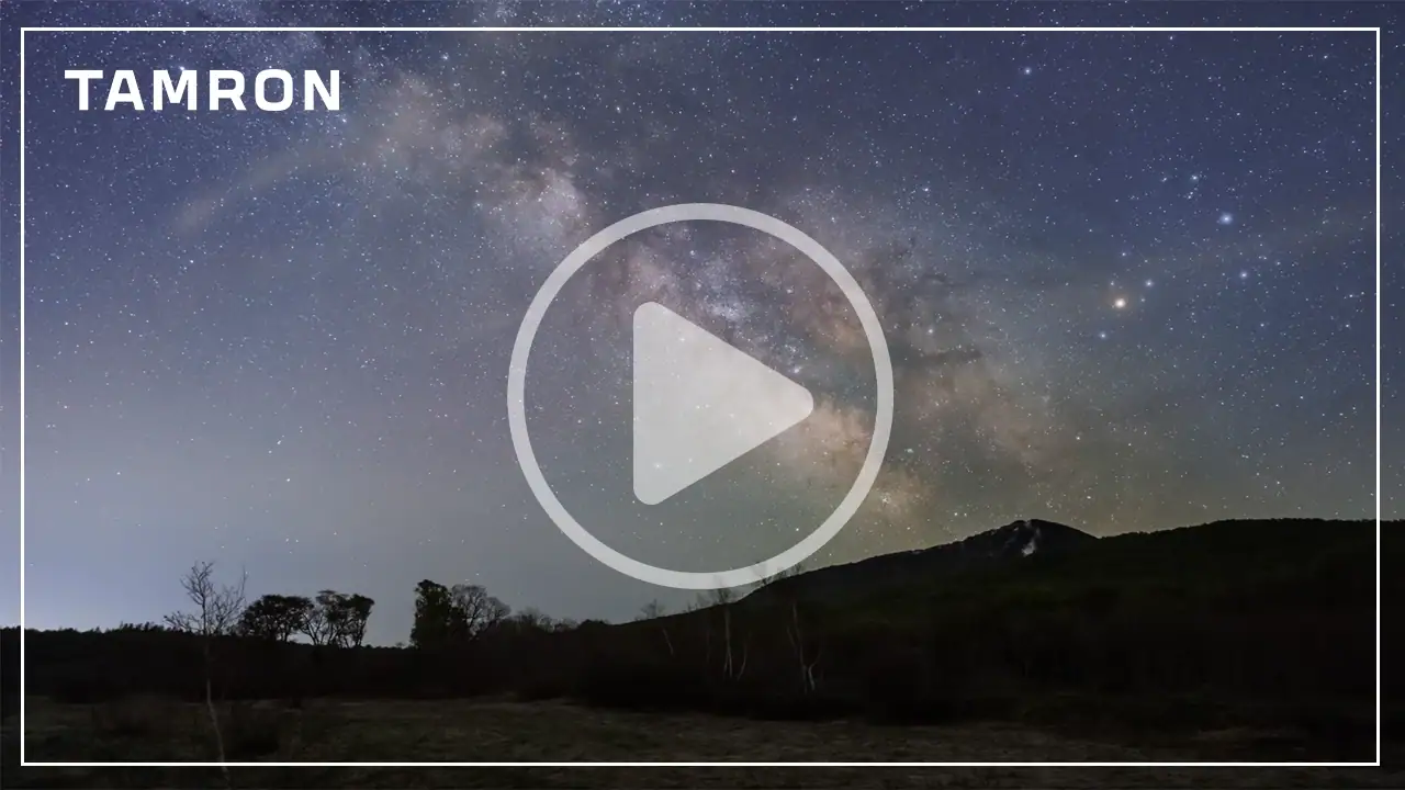 Miniatura de vídeo do TAMRON mostrando o lapso de tempo da Via Láctea sobre uma paisagem montanhosa no céu noturno para demonstração do Astro Focus Lock.