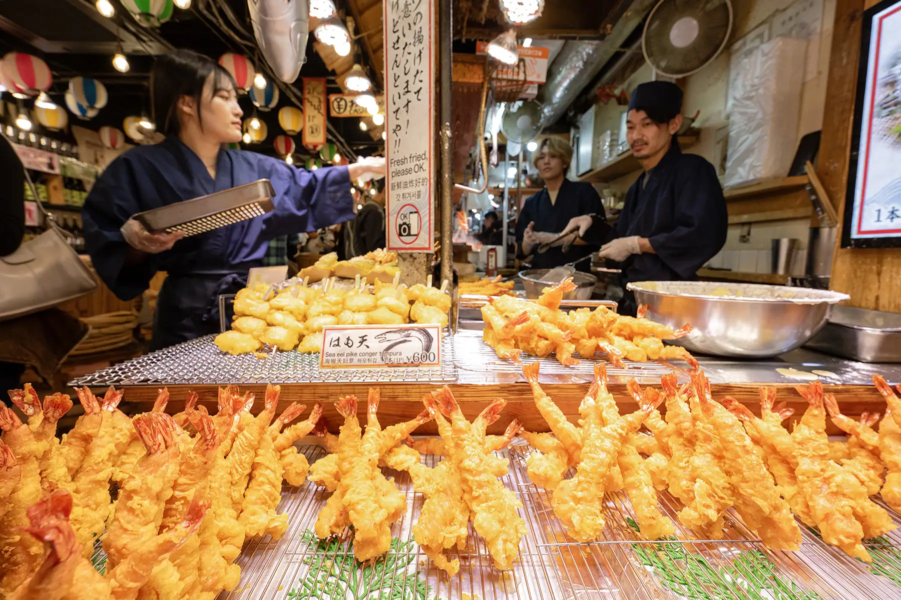 Fish market with a man and woman preparing food.