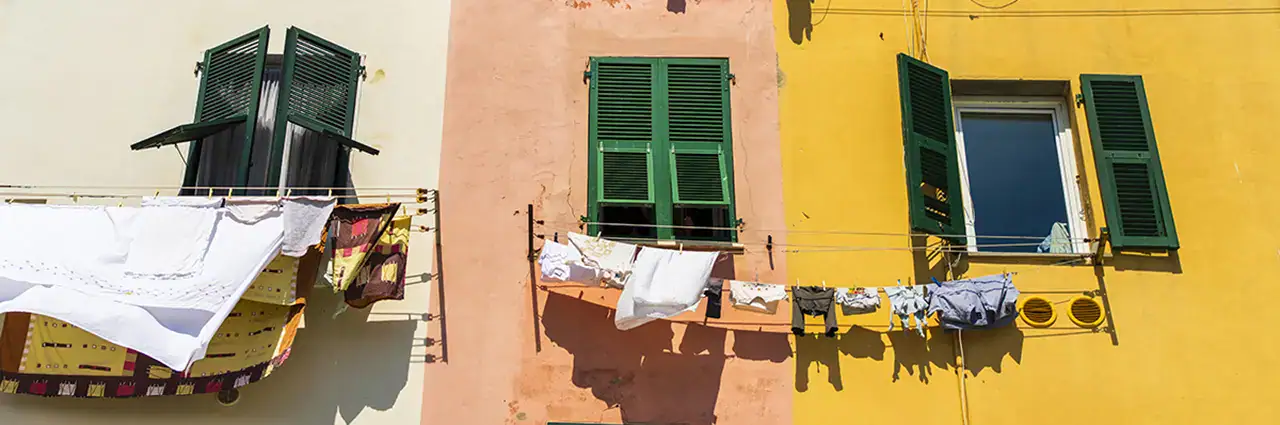 Laundry drying outside colorful buildings, captured with natural light, showing the best lens for street photography in action.
