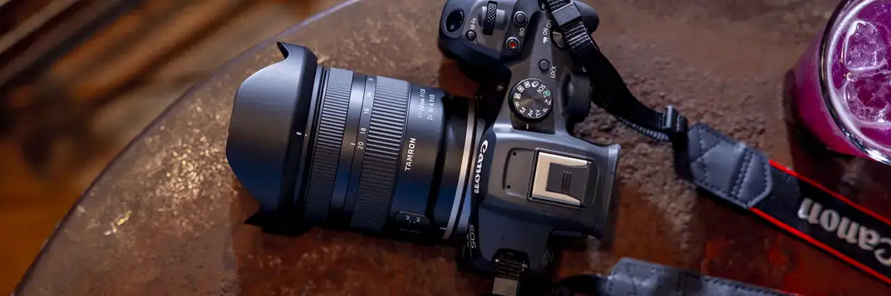 Canon EOS R mirrorless camera with a Tamron 11-20mm F/2.8 RF mount lens resting on a table, highlighting Canon RF mount compatibility.