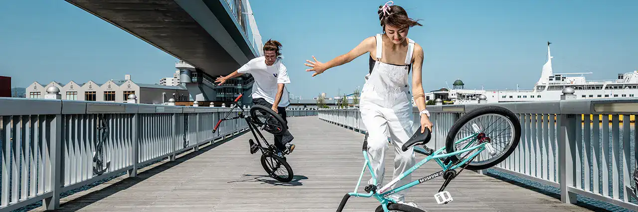 Urban sports photography of BMX riders performing tricks on a boardwalk in Aomori, Japan