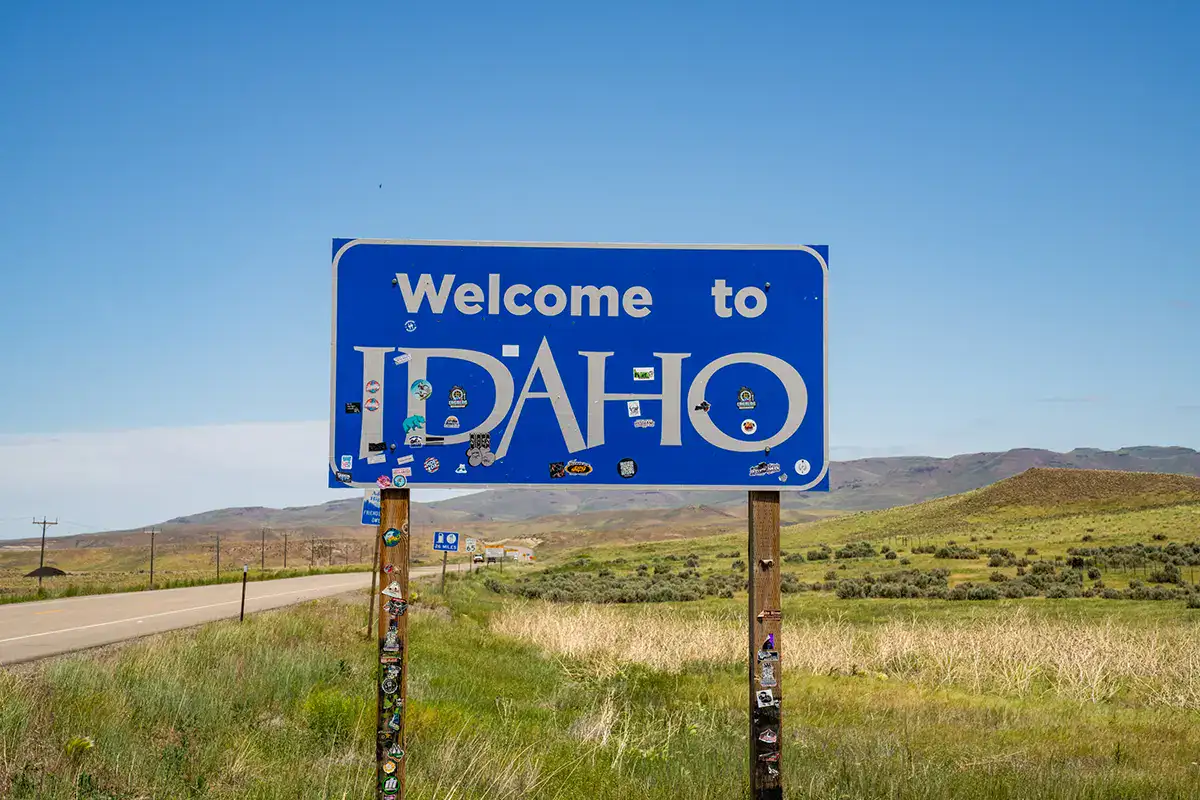 Bienvenido a Idaho signo en la carretera escénica, perfecto para la fotografía de viaje por carretera consejos inspiración.