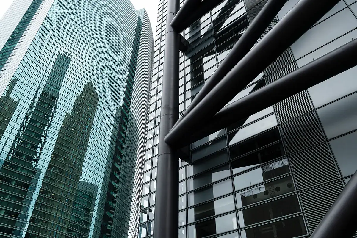 Modern glass skyscraper architecture photographed with a Tamron RF mount wide-angle lens on a Canon EOS mirrorless camera.