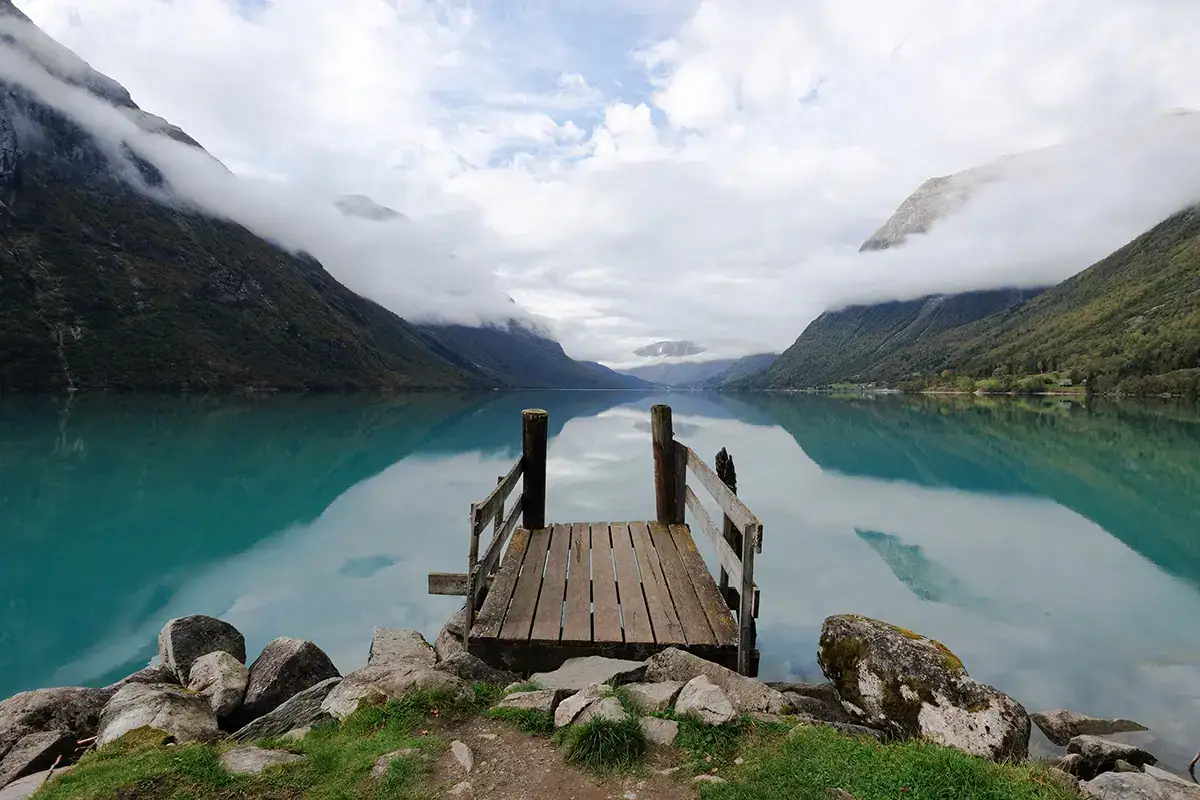 Wide-angle landscape photo of a wooden dock over turquoise water, captured with a Tamron RF mount lens on a Canon EOS mirrorless camera