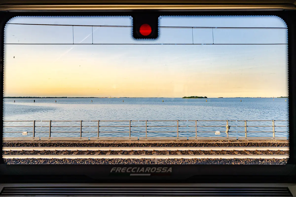 View of the Venetian Lagoon from a Frecciarossa train window, capturing the approach to Italy&rsquo;s Floating City for this Venice travel photography guide.