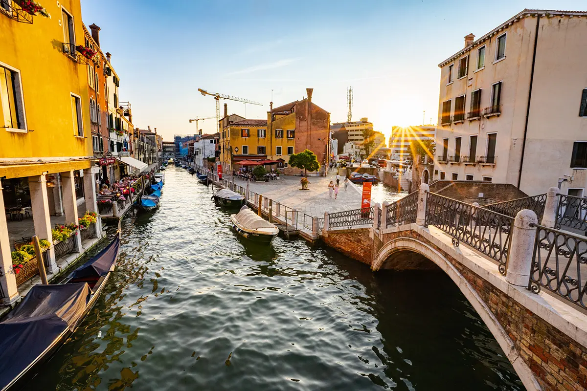 Sunset light over a quiet canal and pedestrian bridge in Venice, Italy, captured for this Venice travel photography guide.