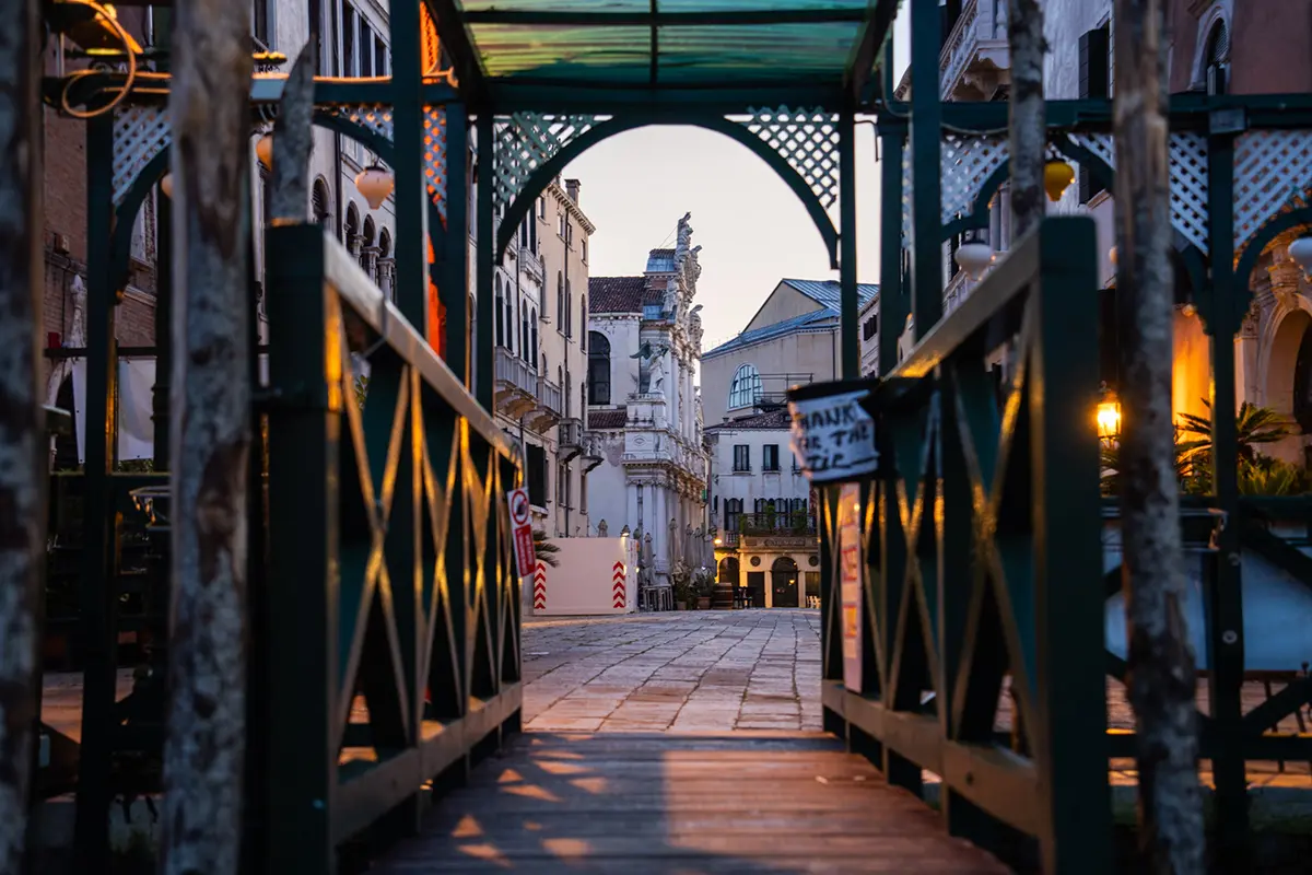 Early morning light frames Venetian architecture through a wooden walkway, adding atmosphere to this Venice travel photography guide.