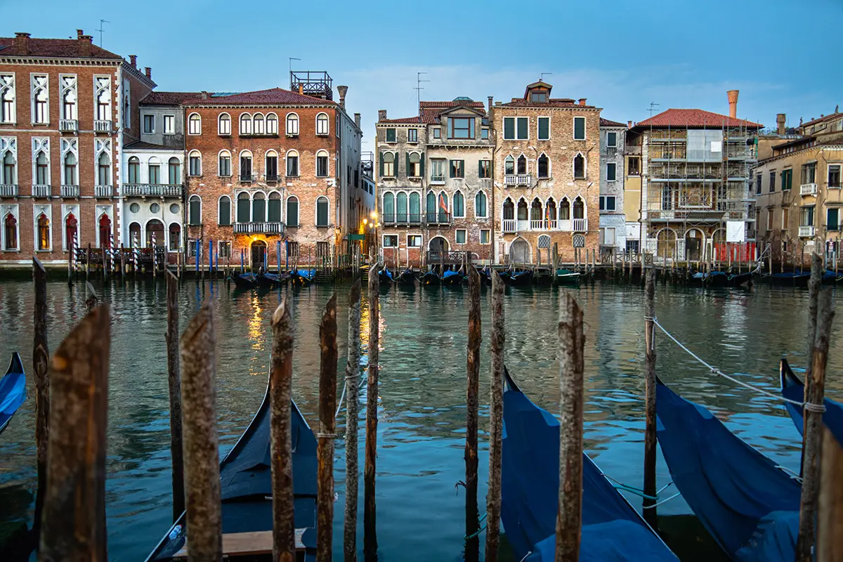 Morning view of gondolas tied along the Grand Canal with historic Venetian architecture, featured in this Venice travel photography guide.