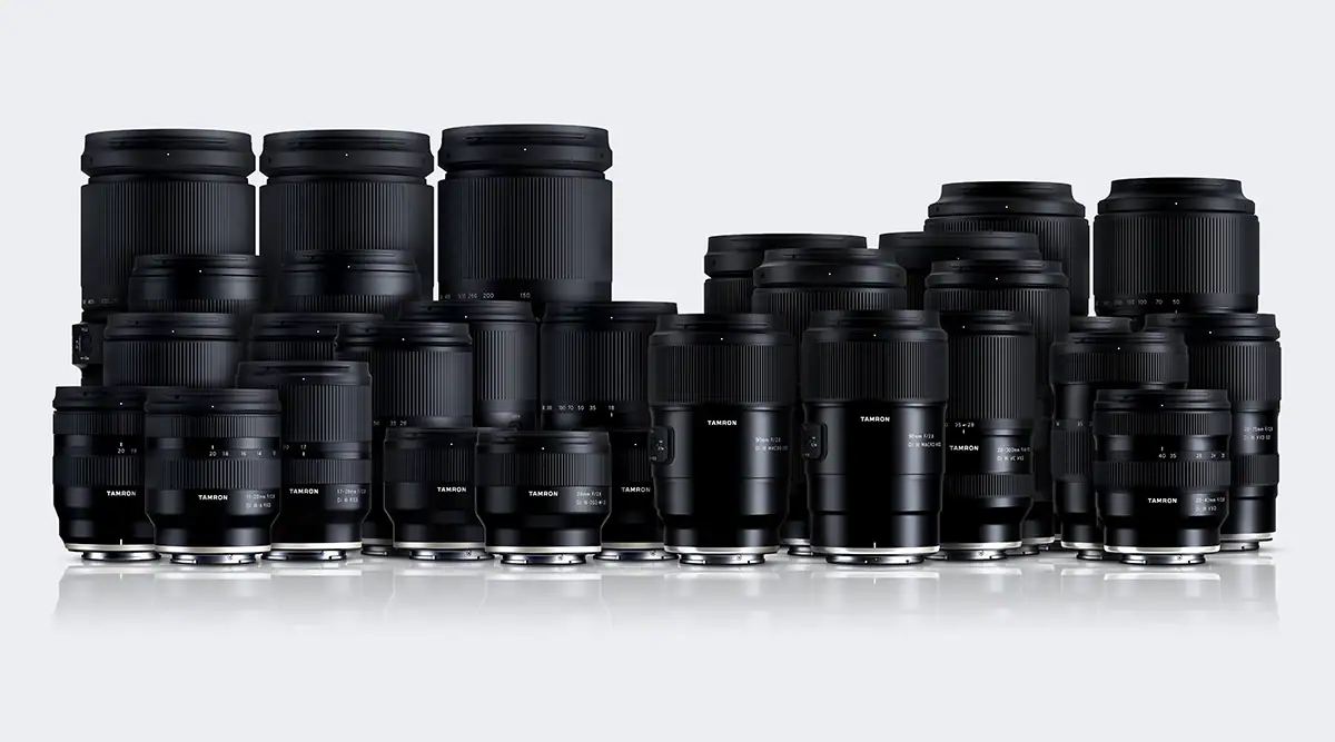 Group image of multiple TAMRON mirrorless camera lenses arranged side by side, showcasing various focal lengths and designs.