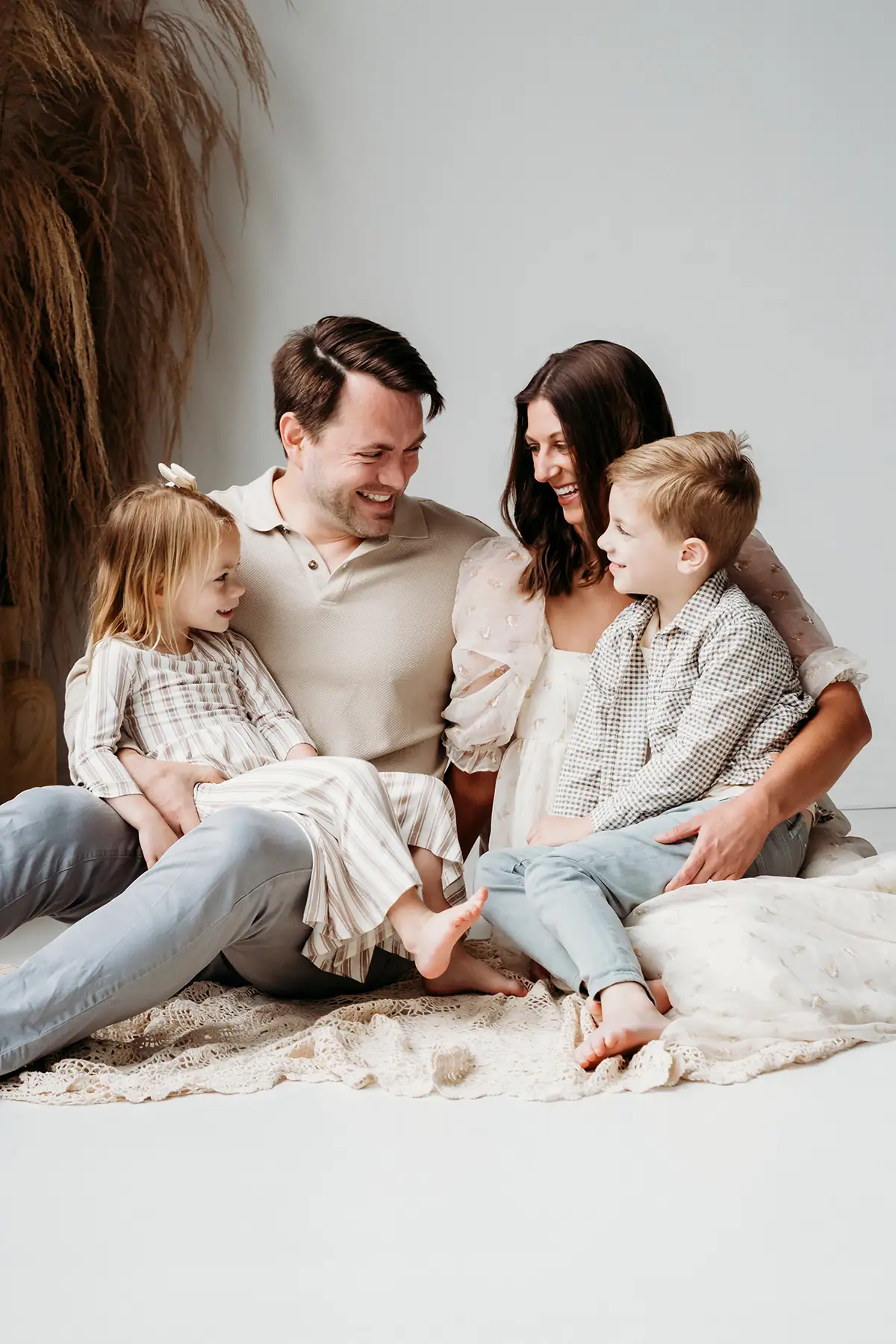 Family sitting together indoors laughing and interacting during a relaxed family photography session.