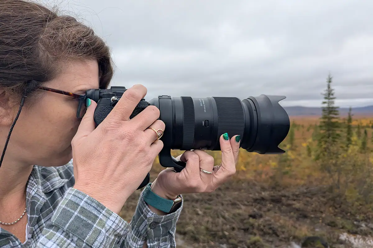 Alyce Bender holding camera with Tamron lens for shooting Alaska fall colors.