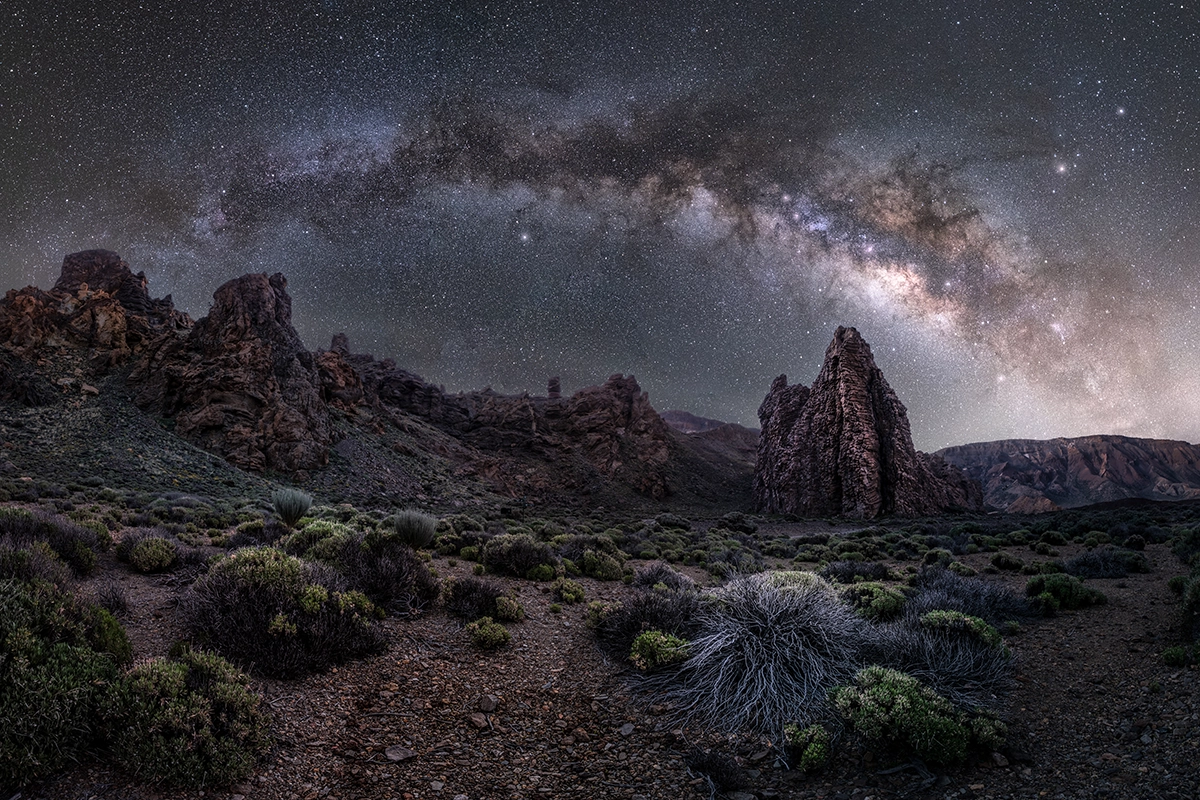 Milky Way galaxy photographed above rocky landscape with an APS-C camera, showing night sky detail and clarity.