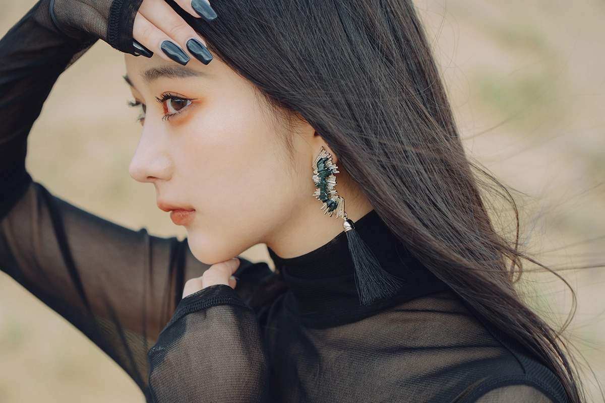 Close-up portrait of a woman with long hair photographed using an APS-C camera, showing detail and sharpness with soft background blur.