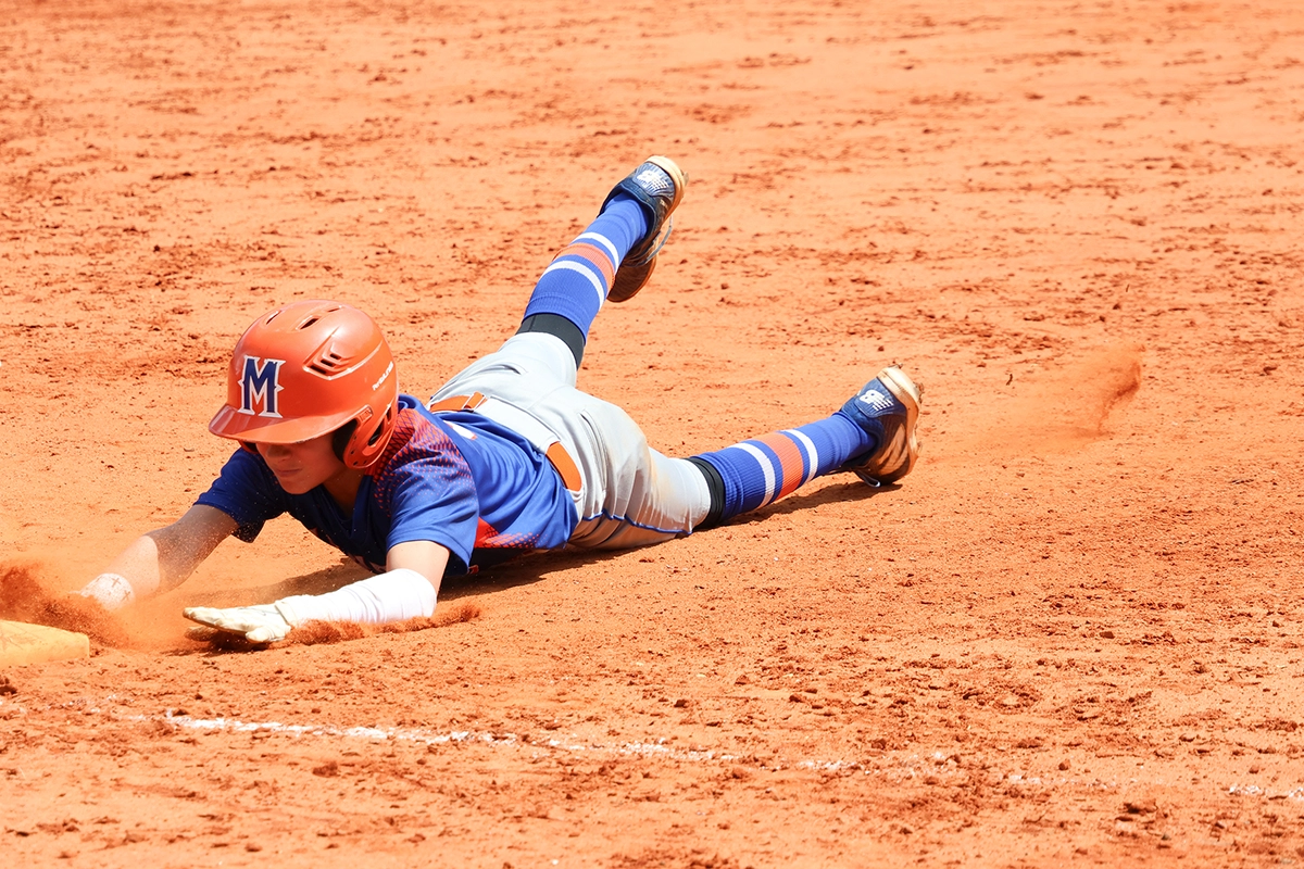 Baseball player sliding into base captured with an APS-C camera, showing crop factor advantage for sports photography