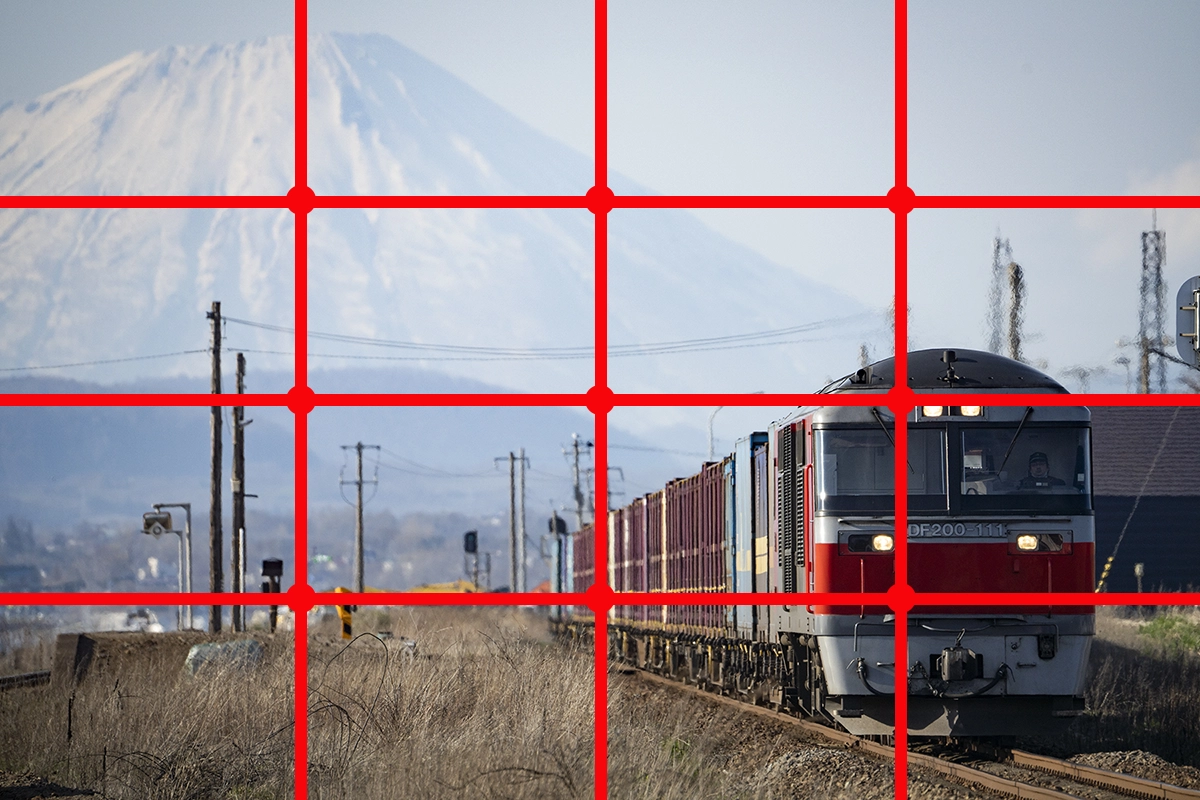 Freight train with mountain in the background, overlaid with a red rule of fourths grid to demonstrate composition.