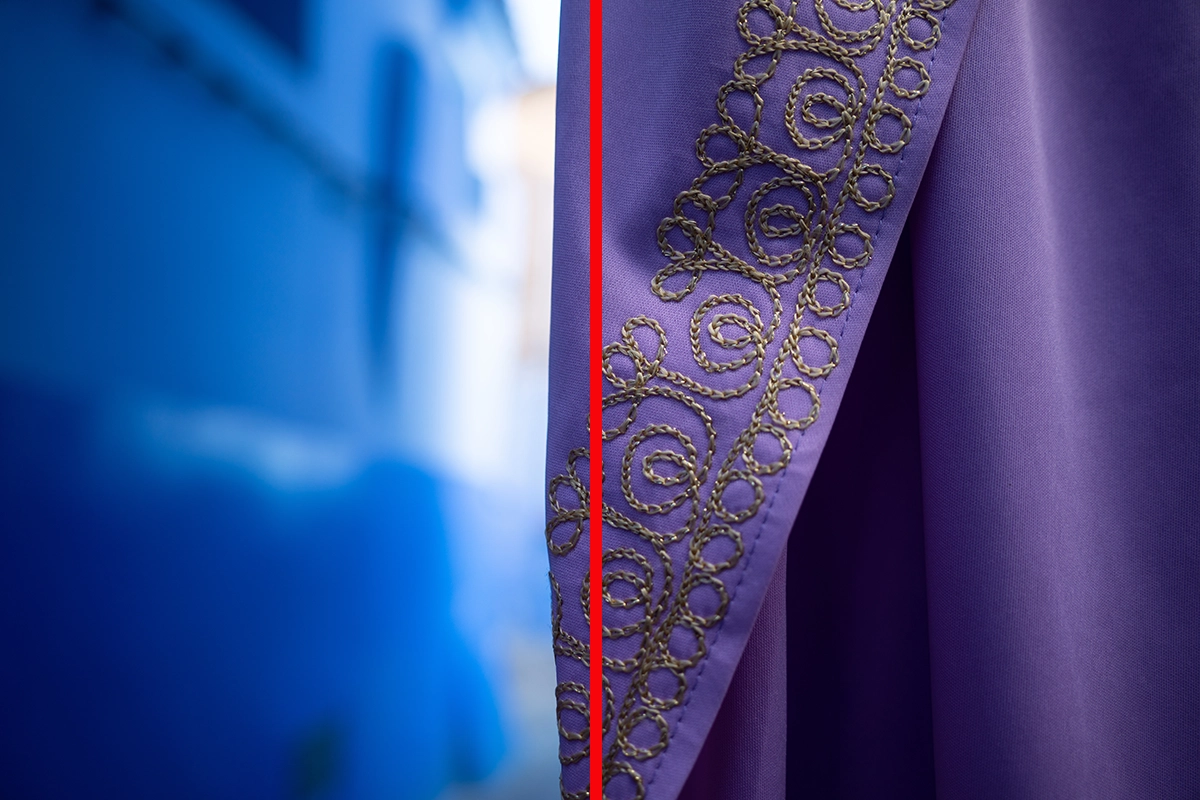 Close-up of a purple embroidered fabric against a blurred blue wall, divided by a vertical red line to illustrate split composition.