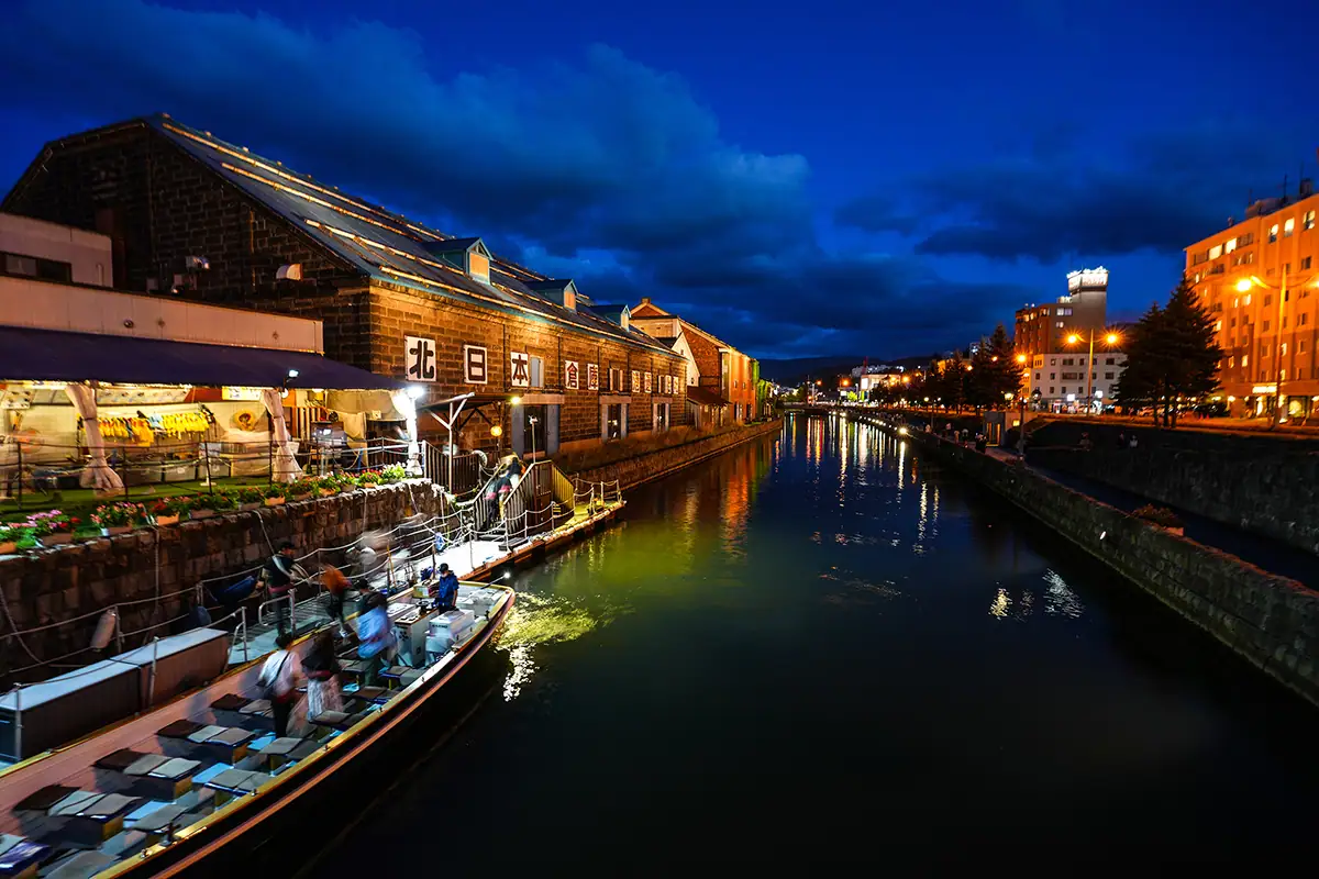 Riverfront town buildings and lights during blue hour.