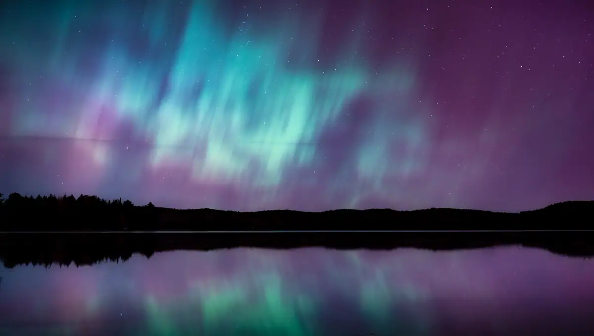Aurores boréales aux nuances vives de bleu sarcelle et de violet se reflétant sur un lac calme sous un ciel étoilé, photographiées avec l'objectif Tamron 28-75 mm F2.8 G2.