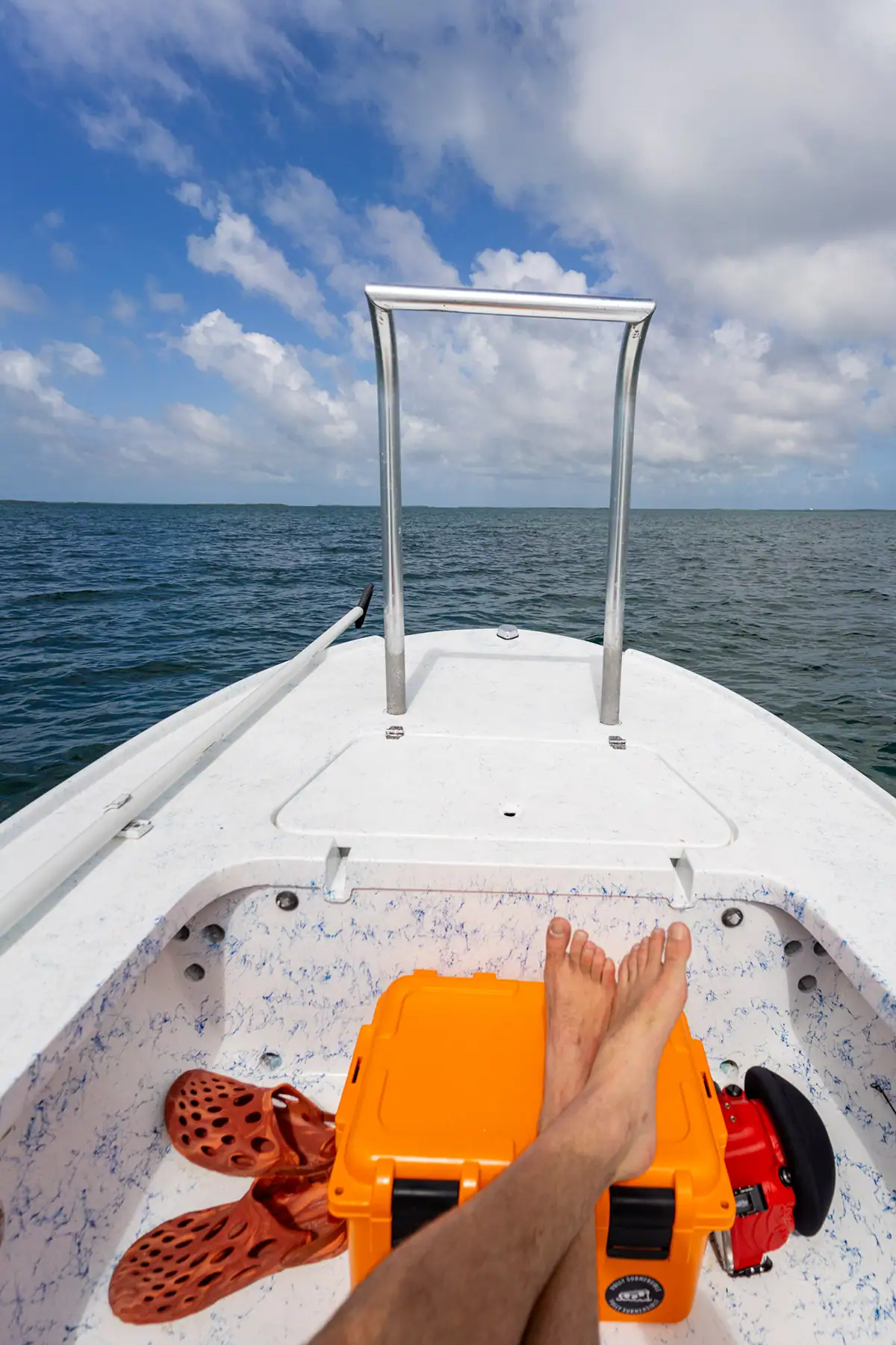 Fly fisherman resting on boat at Turneffe Atoll.