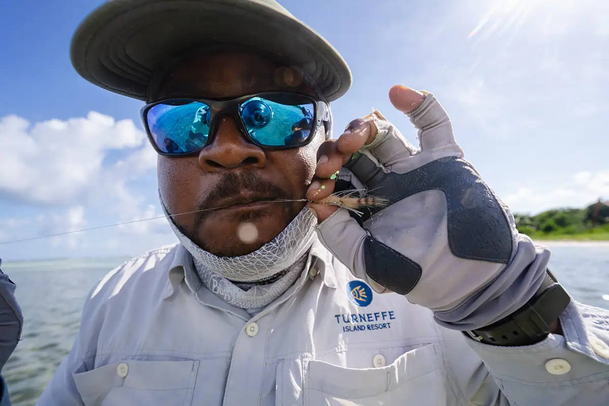 Fly fishing fly close-up in hand at Turneffe Atoll.