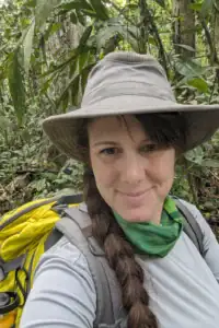 A fotógrafa da floresta tropical Alyce Bender caminhando pela densa vegetação da Costa Rica durante uma expedição de fotografia macro.