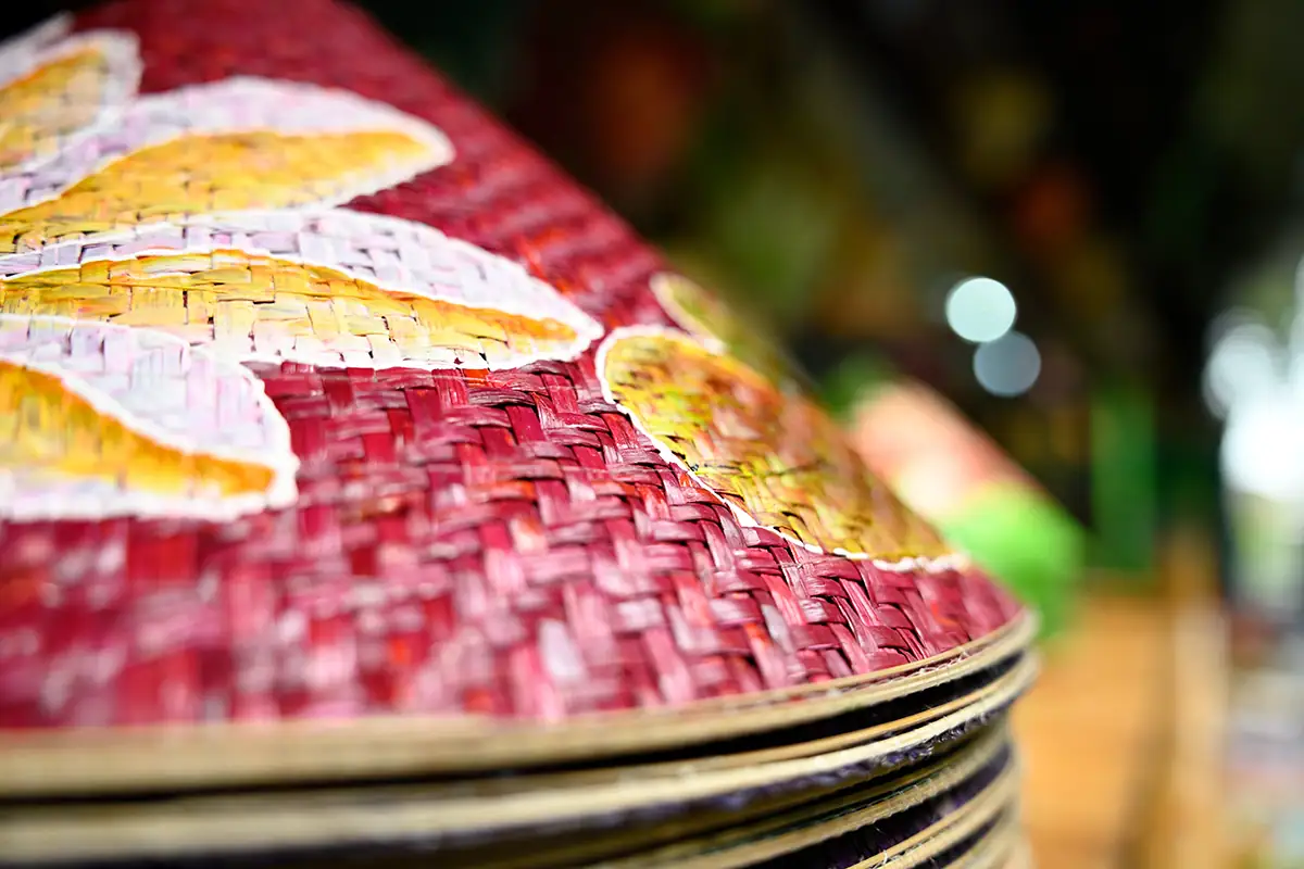 Primer plano de un sombrero vietnamita nón lá pintado a mano que muestra su textura tejida y sus colores vivos, fotografiado con el Tamron 28-75 mm F2.8 G2.