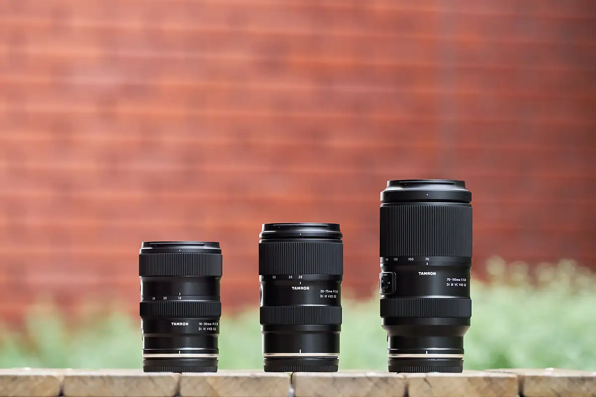 Trois zooms Tamron de longueurs focales différentes disposés côte à côte, illustrant l'influence du choix de la longueur focale sur la taille, la portée et le style de photographie.