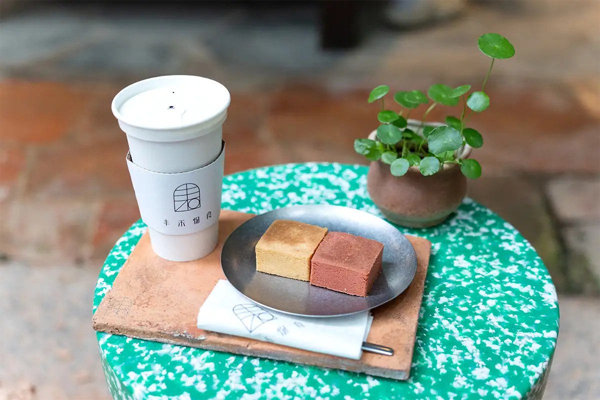 Coffee and dessert on a small outdoor caf&eacute; table in Taiwan, photographed for travel photography with a lightweight Sony E-mount lens.