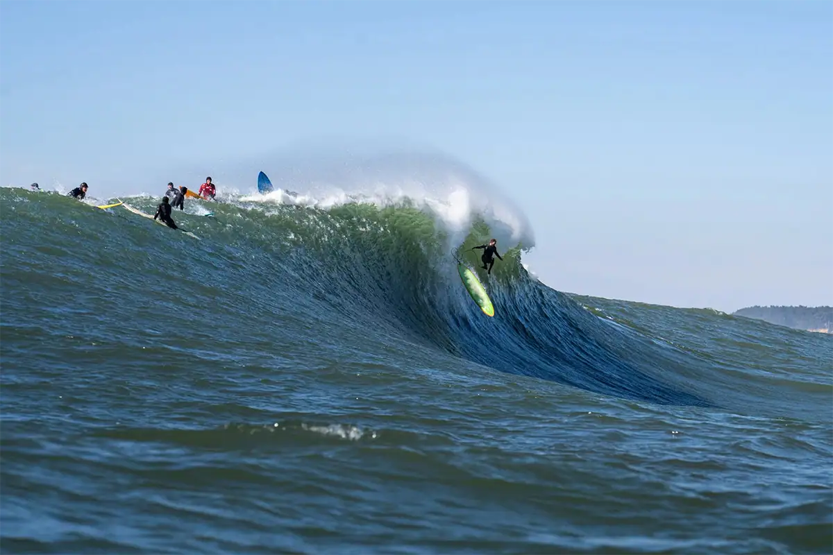 Photographie de surf d'un surfeur se jetant dans une grande vague déferlante à Mavericks à Half Moon Bay, Californie.