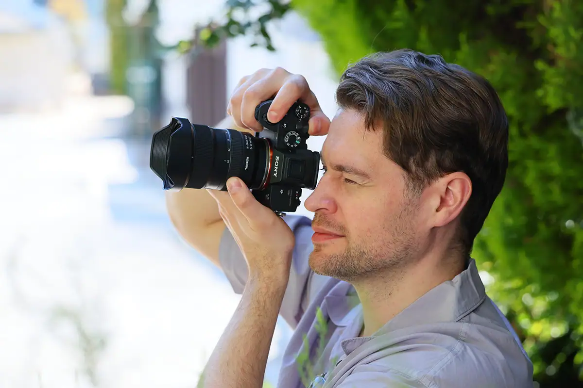 Fotógrafo utilizando un objetivo Tamron 16-30 mm F/2.8 Di III VXD G2 en una cámara sin espejo Sony en exteriores.