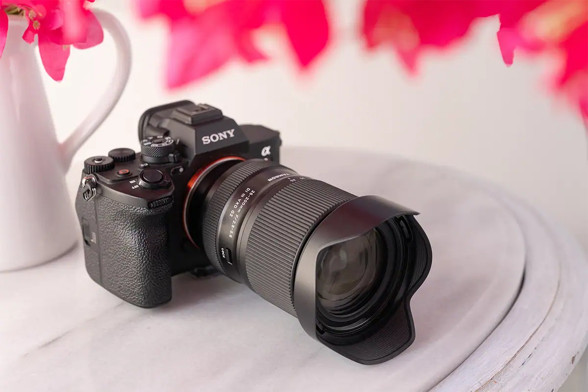 Lente Tamron 25-200 mm F/2.8-5.6 Di III VXD G2 (modelo A075) montado en una cámara sin espejo Sony sobre una mesa.