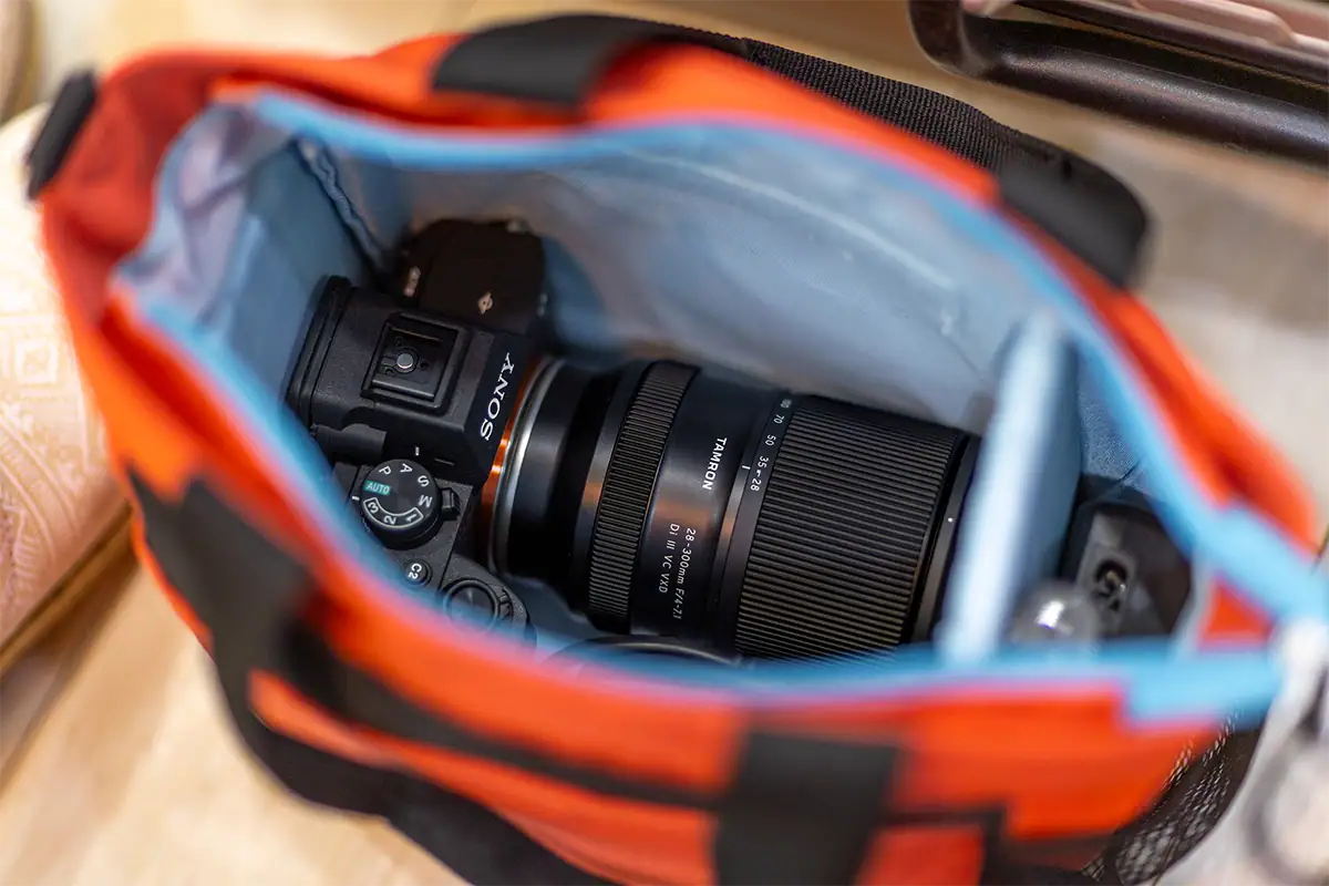 Lente Tamron 28-300 mm F/4-7.1 Di III VC VXD (modelo A074) montado en una cámara sin espejo Sony dentro de una bolsa para cámara.