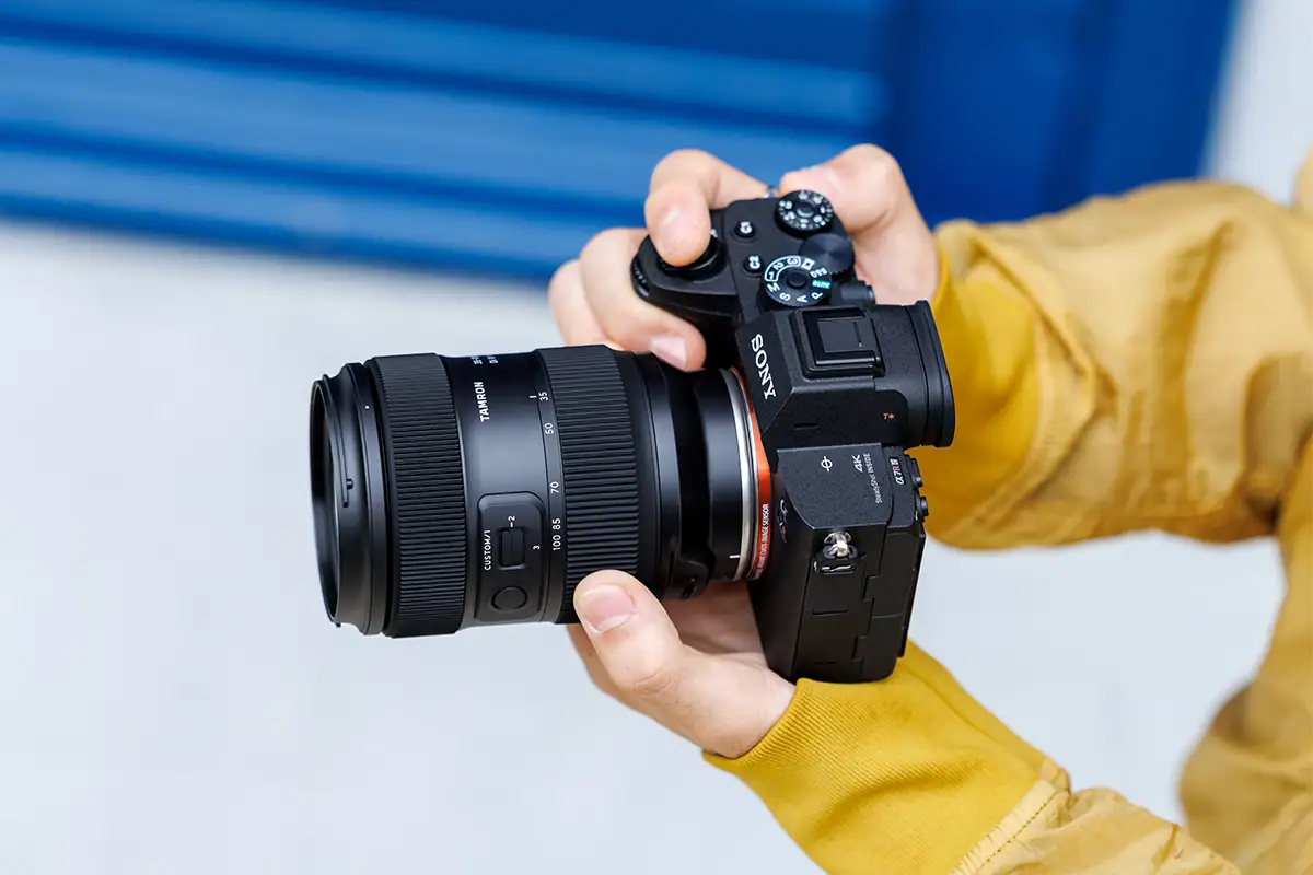 Lente Tamron 35-100 mm F/2.8 Di III VXD (modelo A078) montado en una cámara sin espejo Sony sostenida con la mano.
