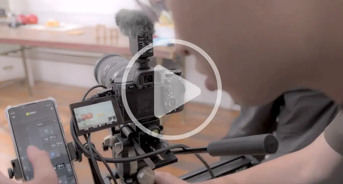 Behind-the-scenes view of a filmmaker adjusting focus on a camera rig using Tamron Lens Utility Mobile during the &ldquo;Perfect Apple Pie&rdquo; shoot.