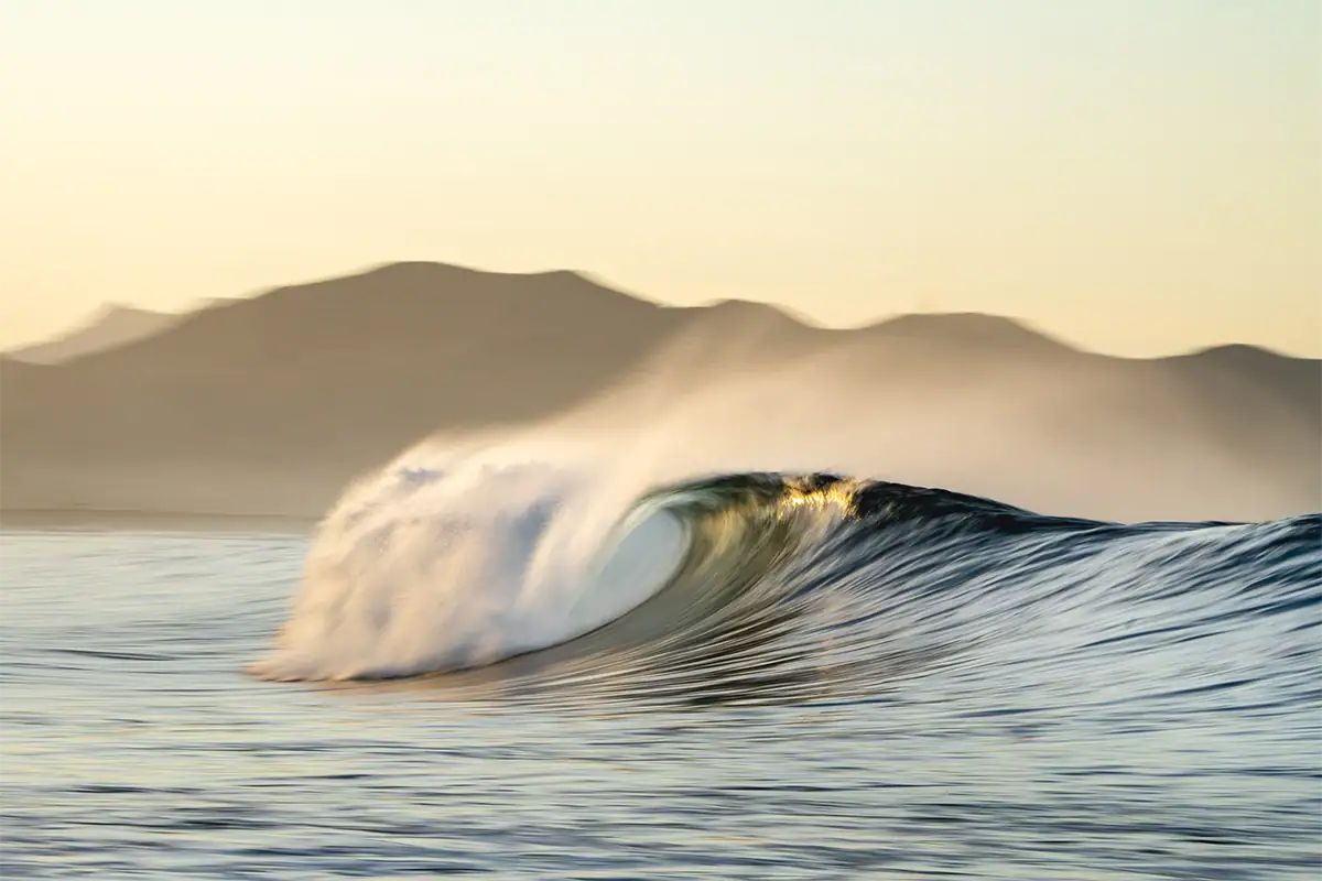Photographie à longue exposition d'une vague déferlante au lever du soleil au large de la côte de Basse-Californie.