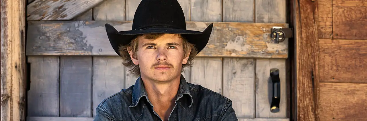 Retrato fotografado com a lente Tamron 35-100 mm F/2.8 Di III VXD durante um workshop de cowboy com luz natural.